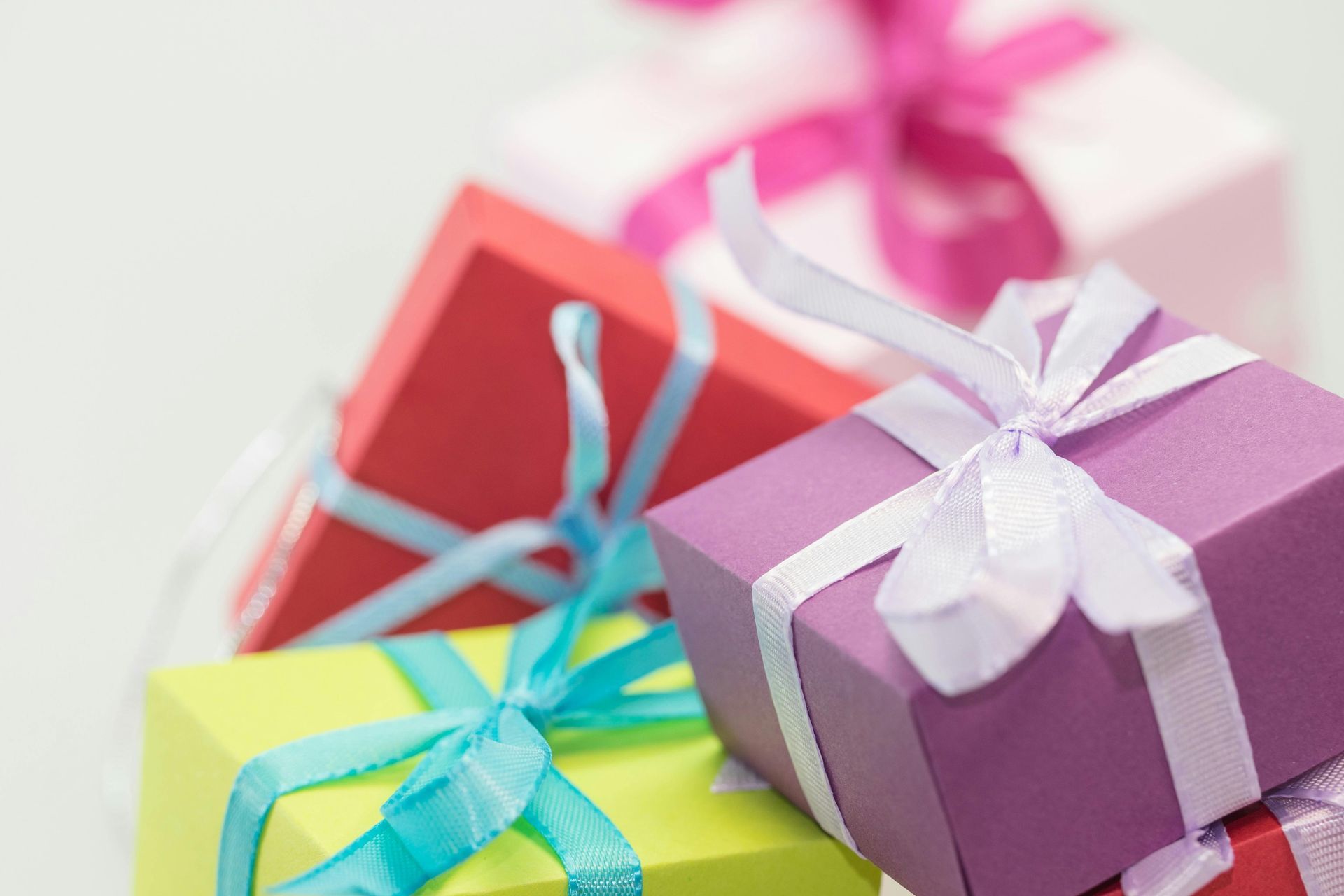 A stack of colorful gift boxes with ribbons and bows.