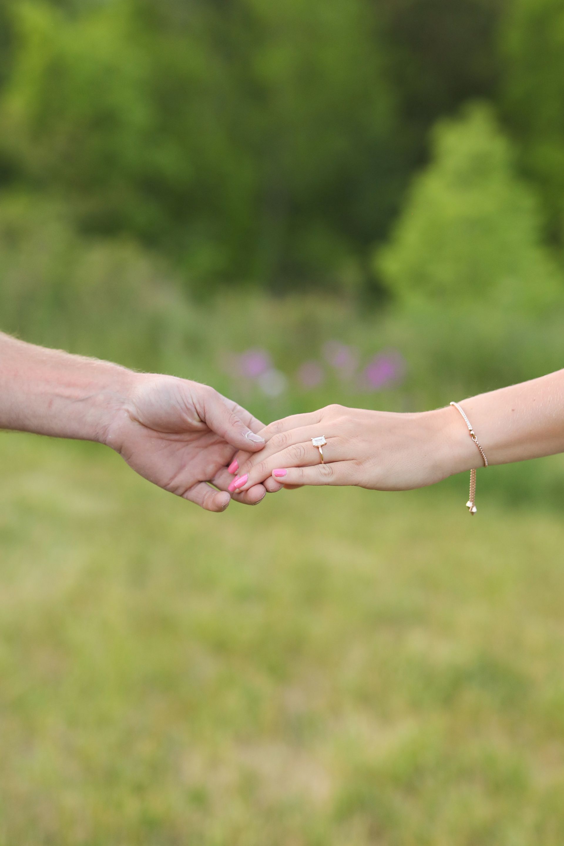 A man and a woman are holding hands in a field.