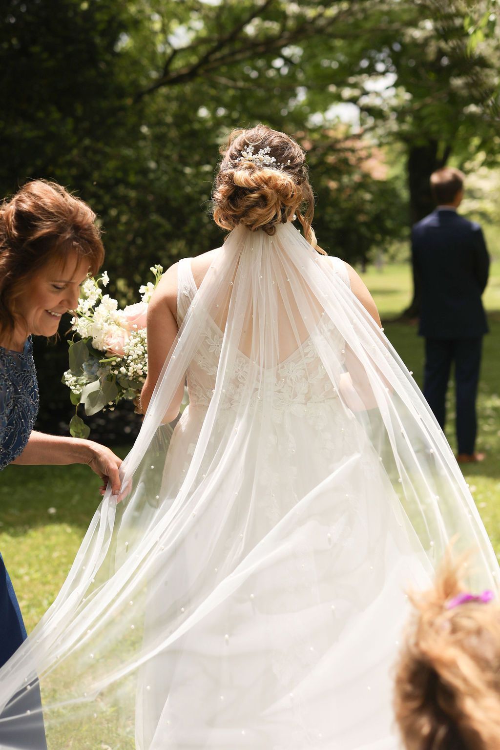 A bride in a wedding dress and veil is walking down the aisle.