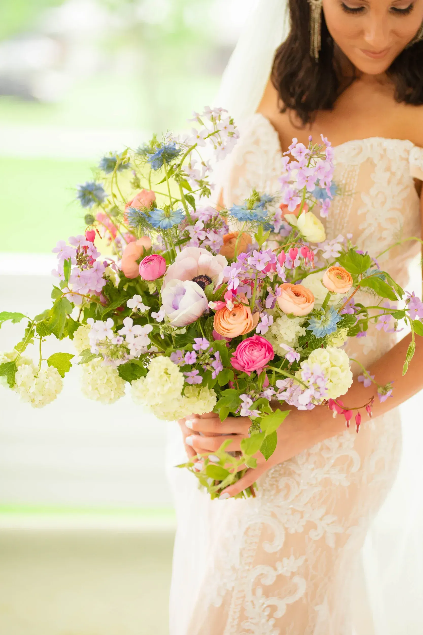 A bride in a wedding dress is holding a bouquet of flowers.
