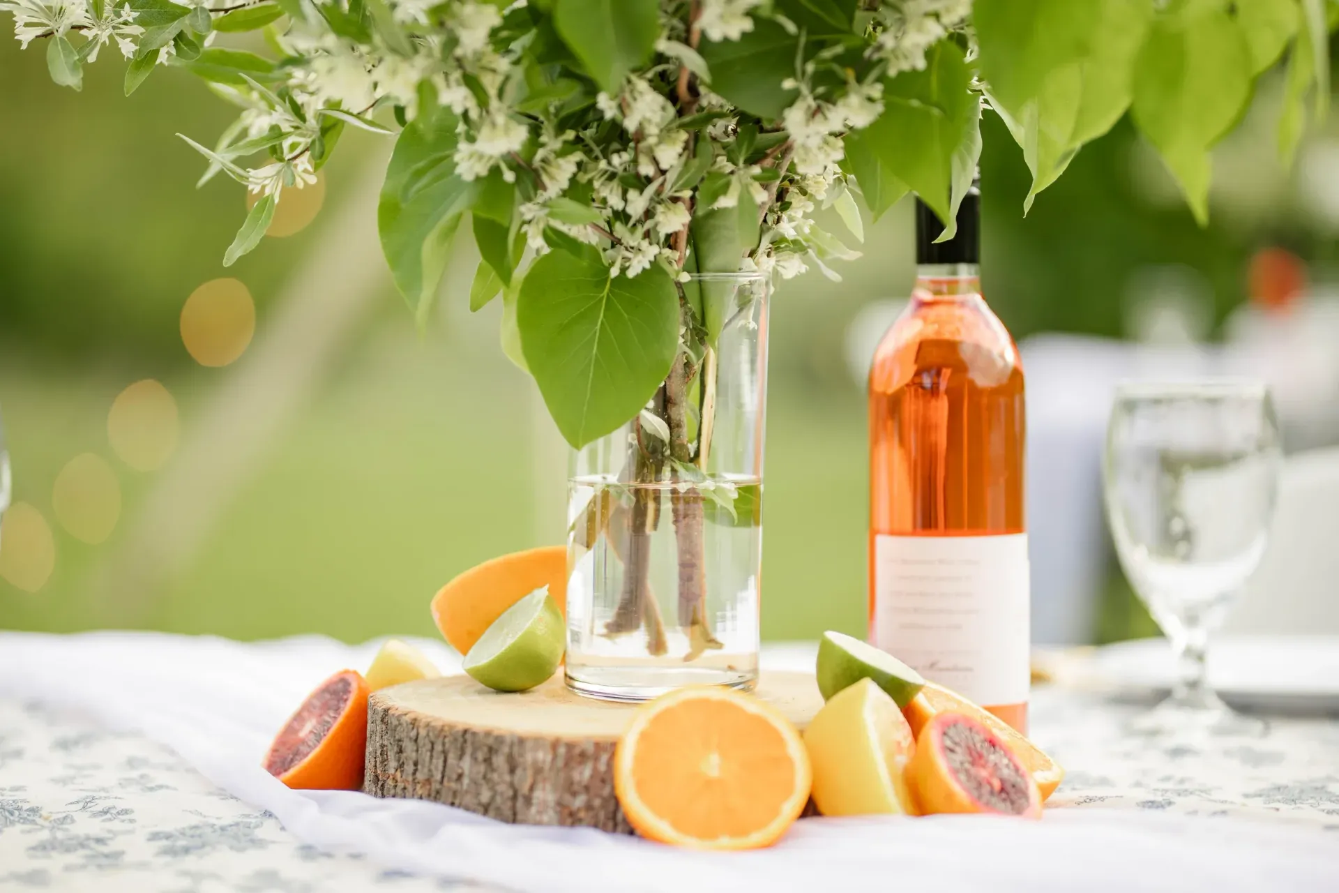 A bottle of wine is sitting on a table next to a vase of flowers.