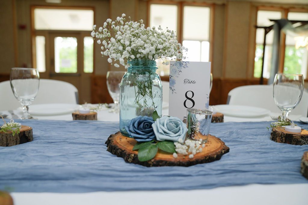 A table with a vase of flowers and a table number on it.