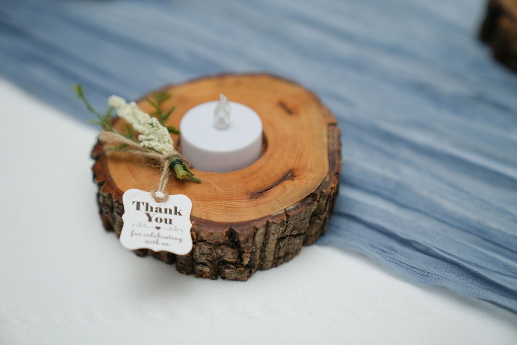 A wooden candle holder with a thank you tag attached to it.