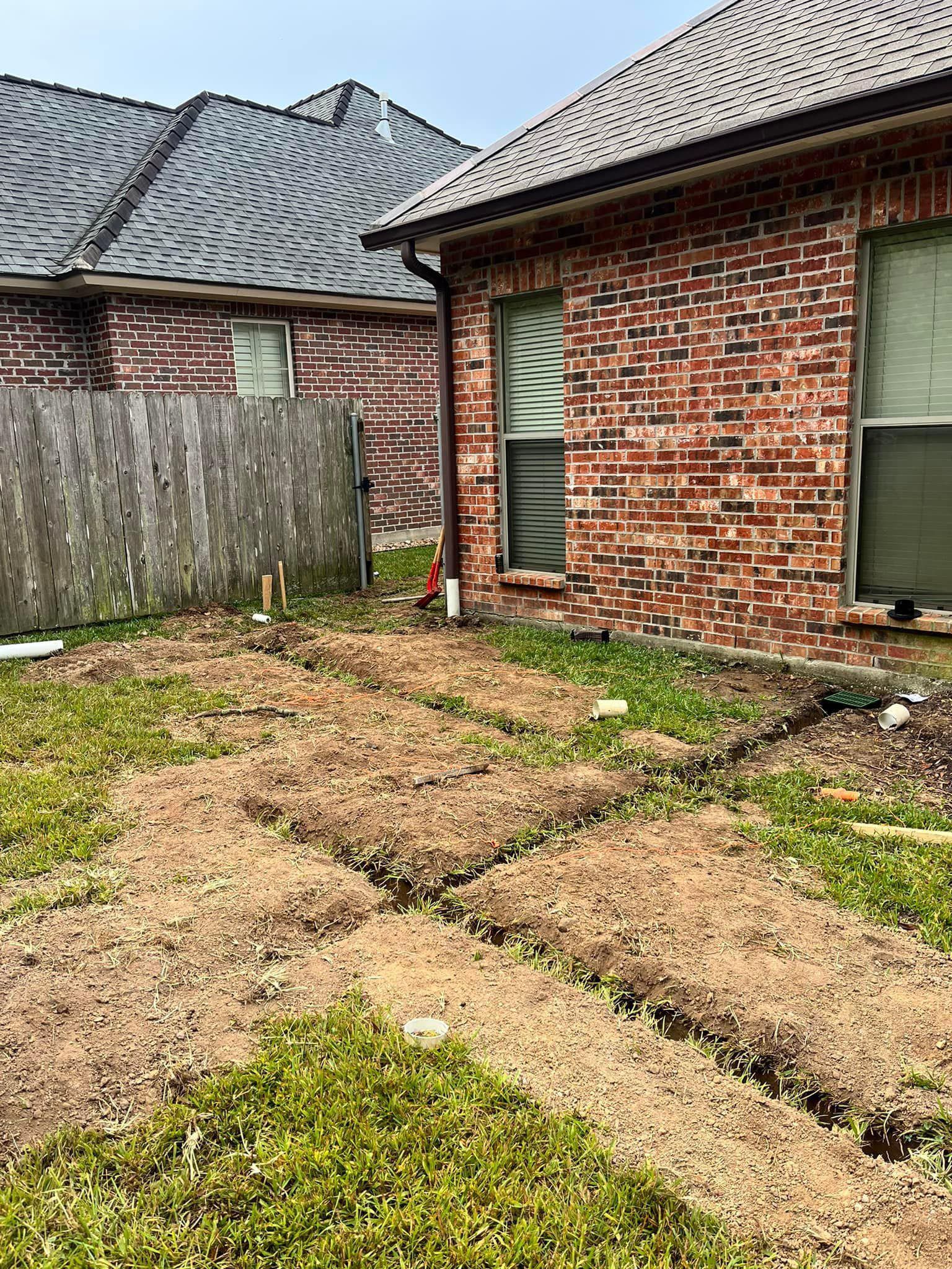 A brick house with a fence and a lot of grass in front of it.