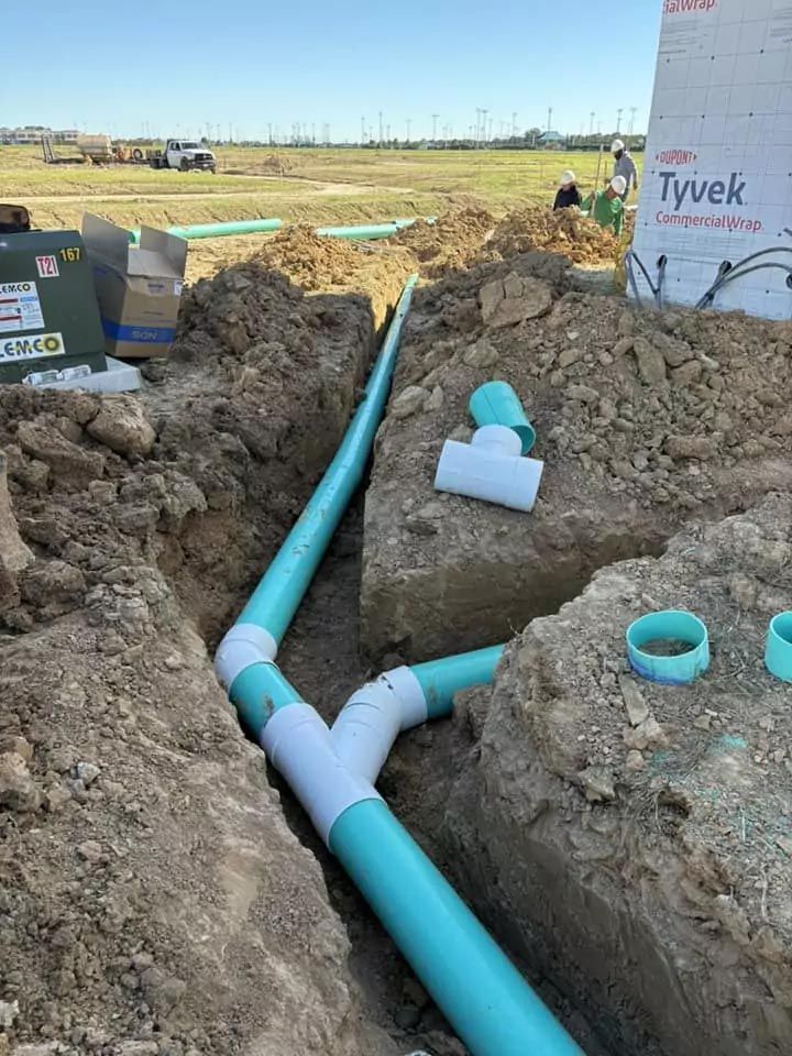 A bunch of pipes are being installed in the dirt.