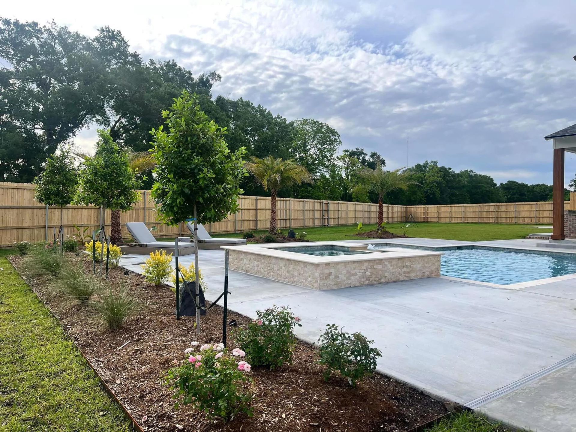 There is a large swimming pool in the backyard of a house.