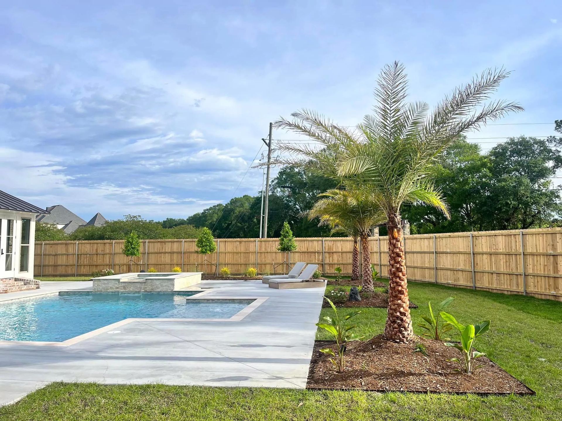 There is a swimming pool in the backyard of a house.