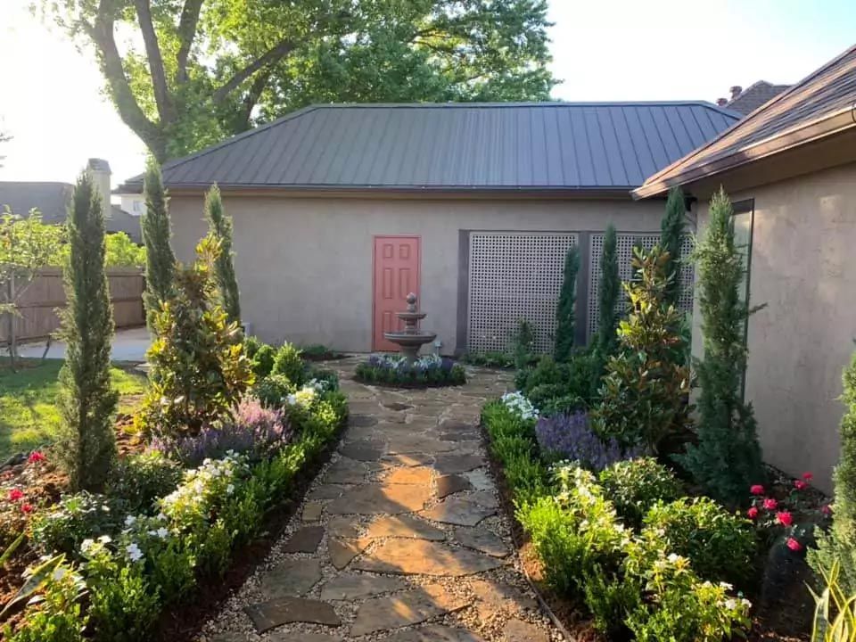 A path leading to a house with a fountain in the middle of it.