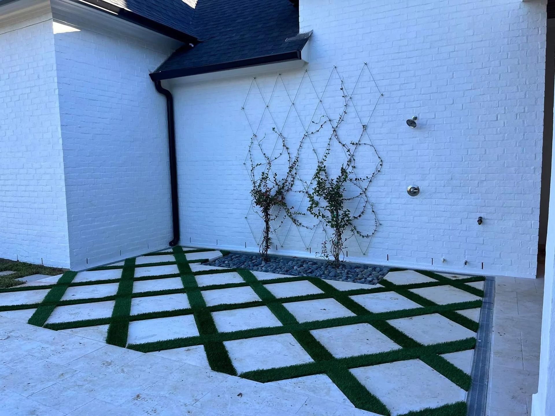 A white brick building with a green lawn in front of it