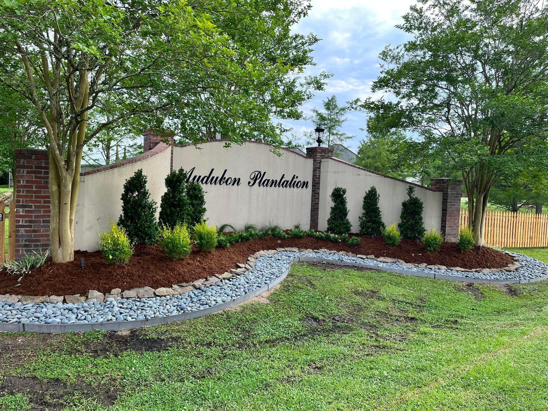 A large sign in the middle of a lush green field.