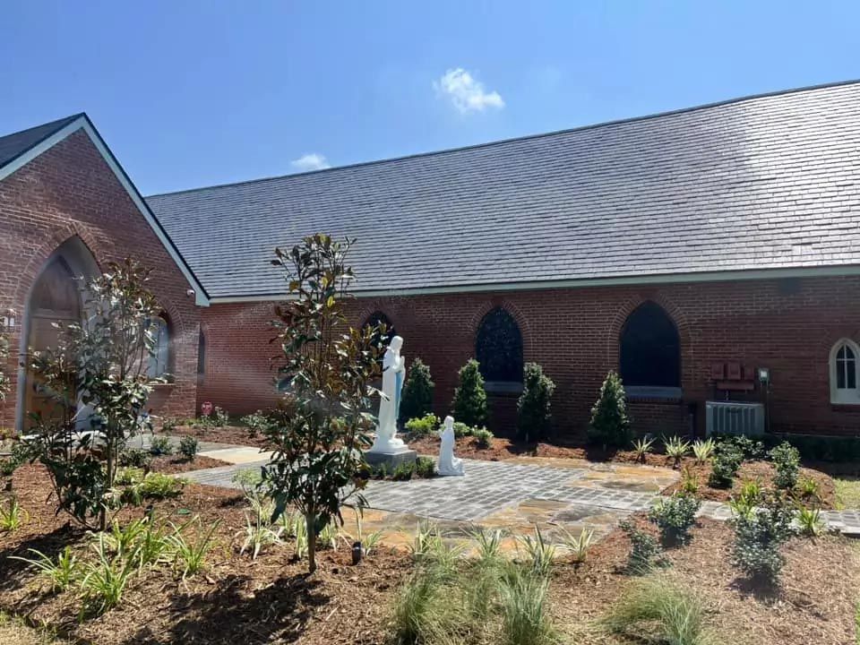 A large brick building with a statue in front of it.