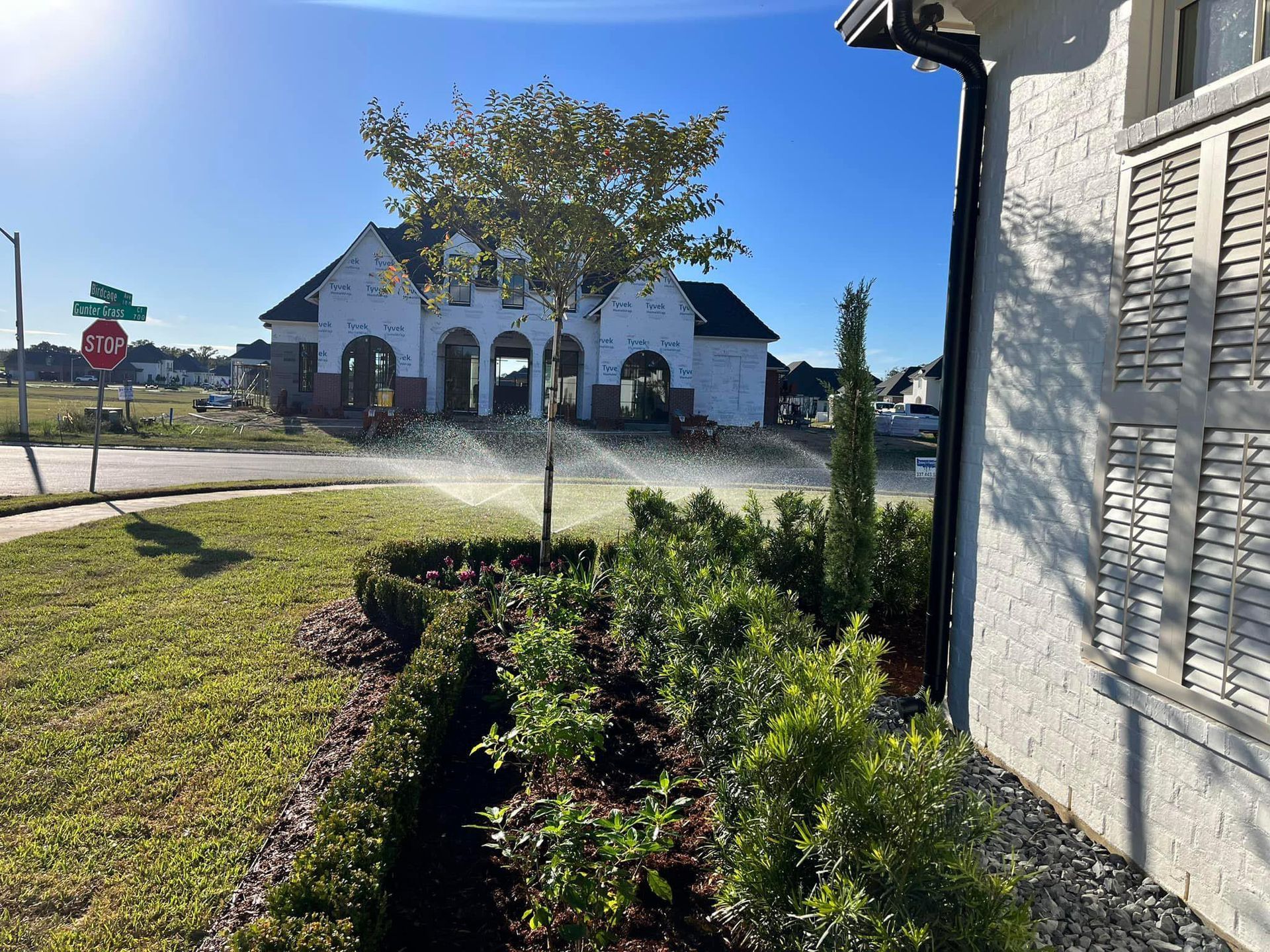 A white house with a sprinkler on the side of it.