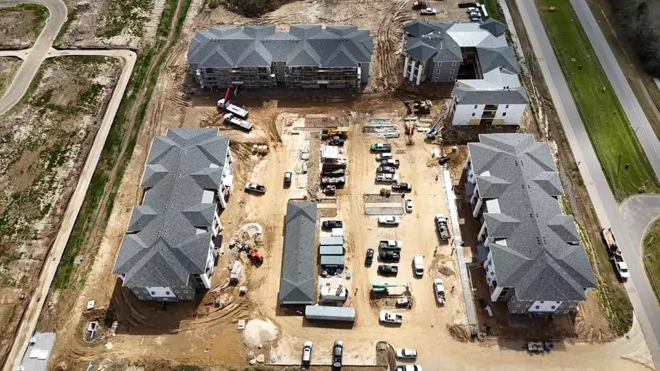 An aerial view of a building under construction in a residential area.