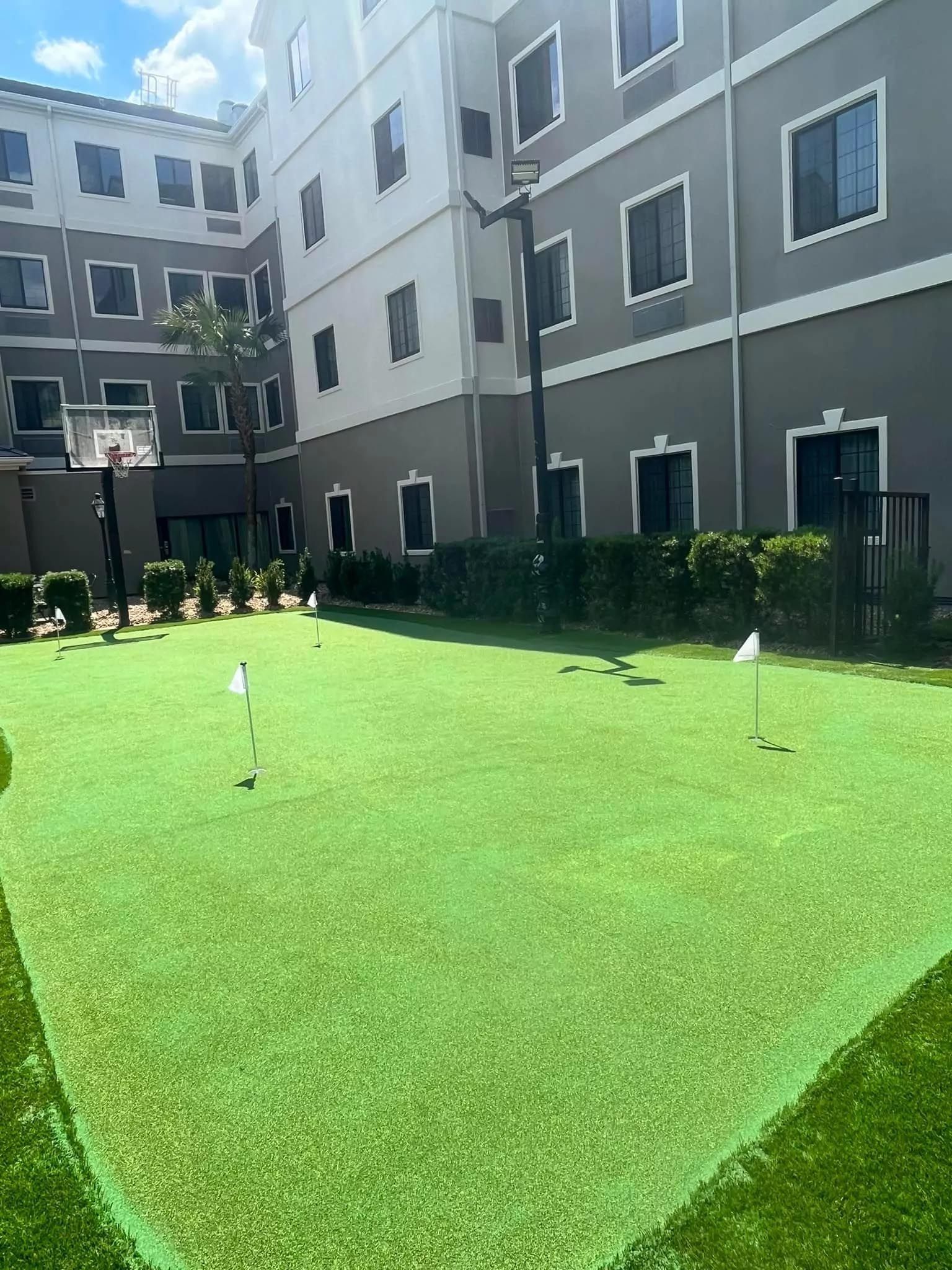 A large building with a putting green in front of it.