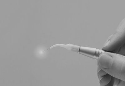 A person is holding a dental laser in their hand.
