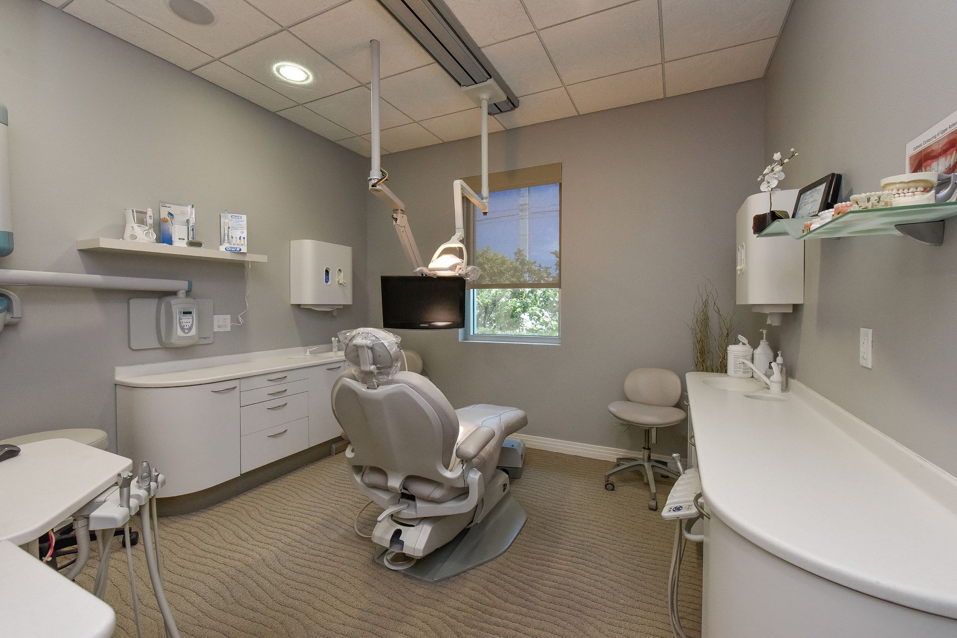A dental office with a dental chair and a monitor
