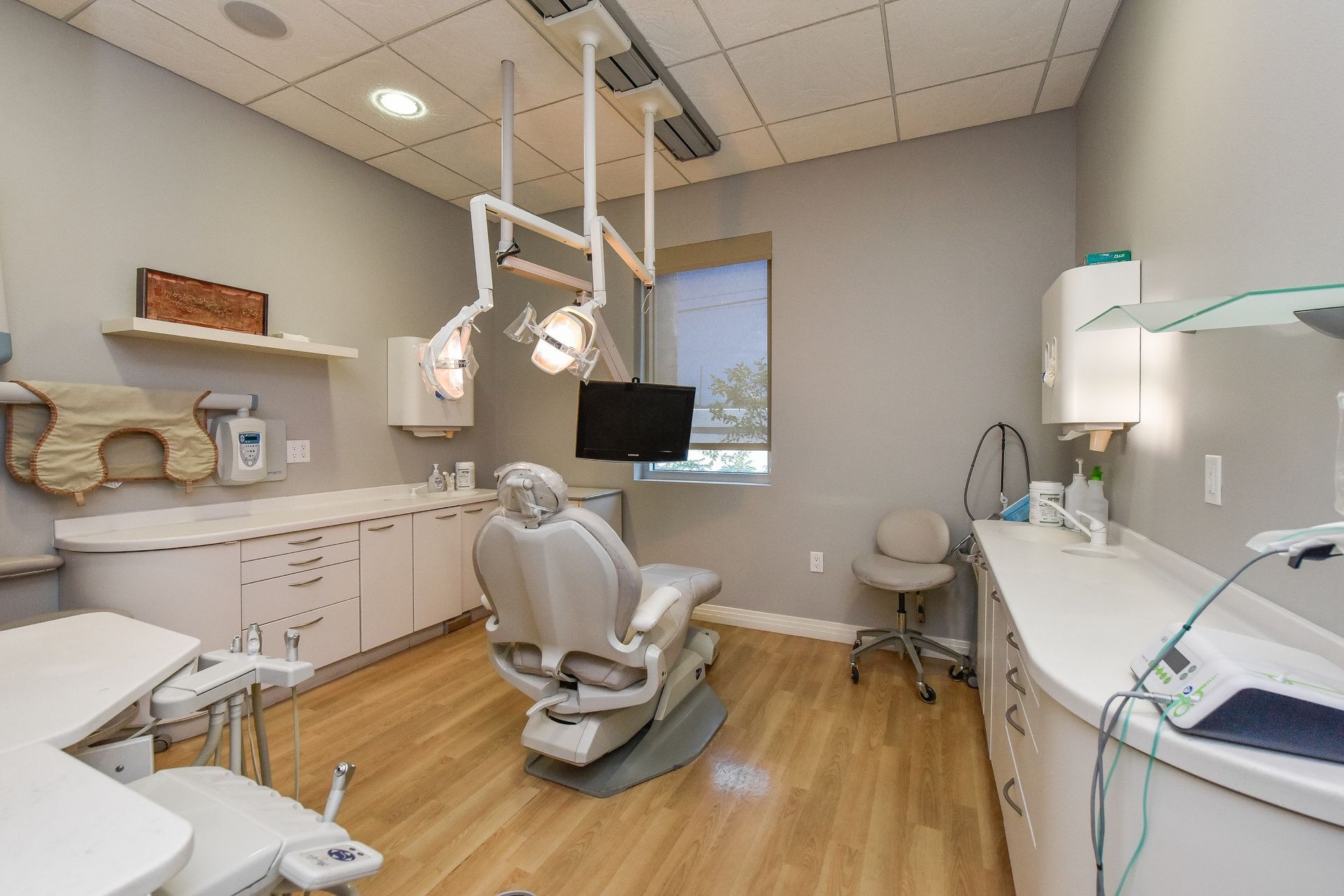 A dental office with a dental chair and a desk.