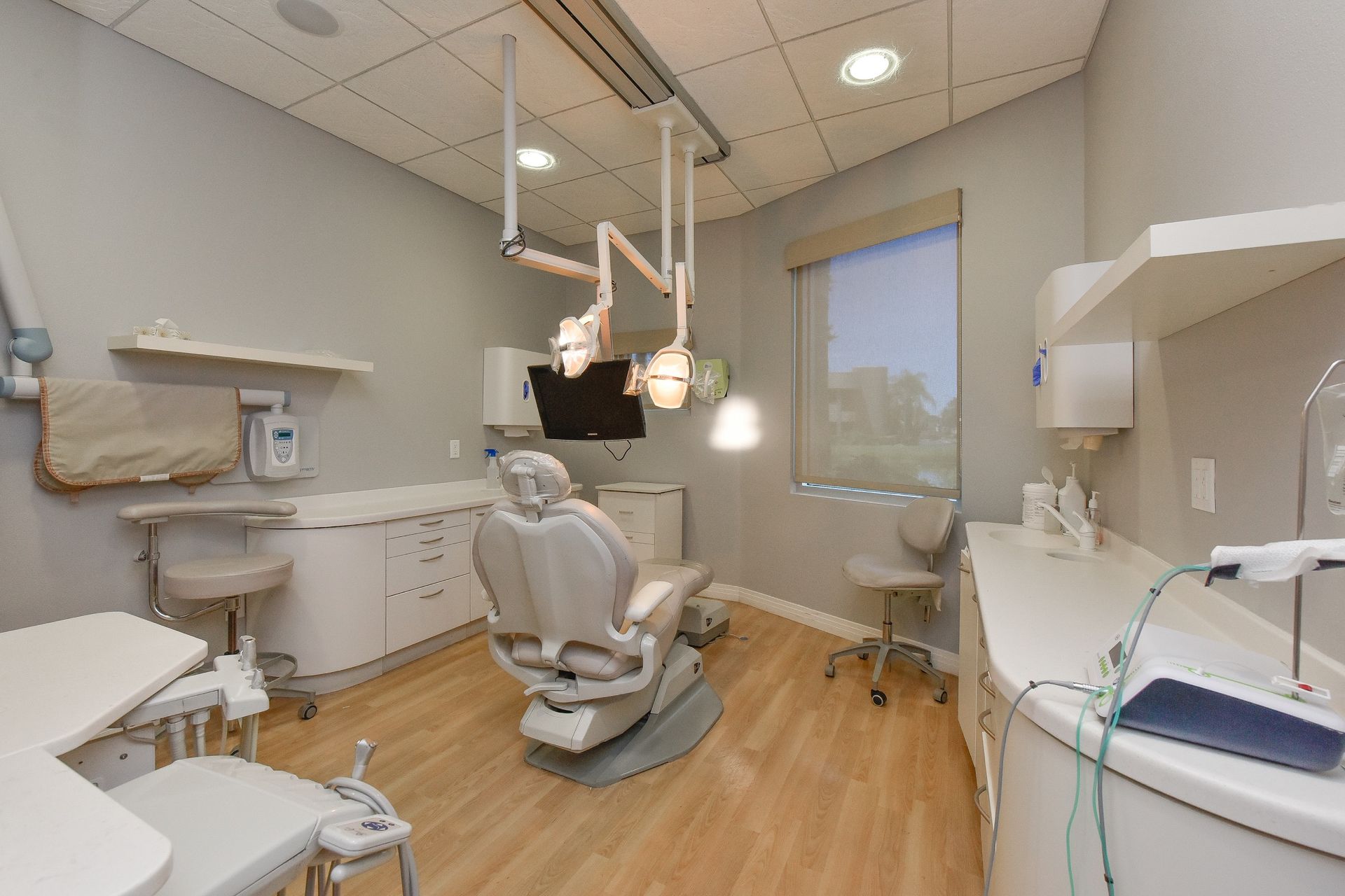 A dental office with a dental chair and a desk.