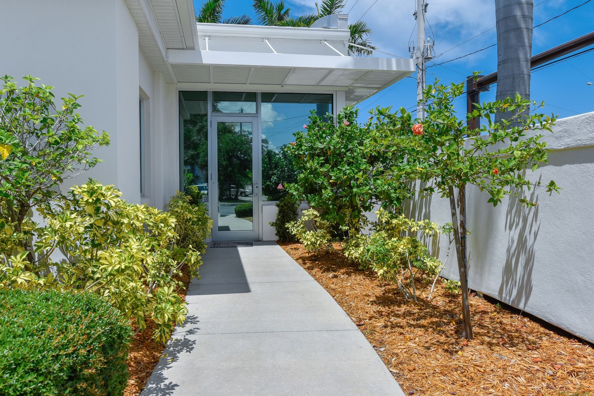 A white building with a walkway leading to it