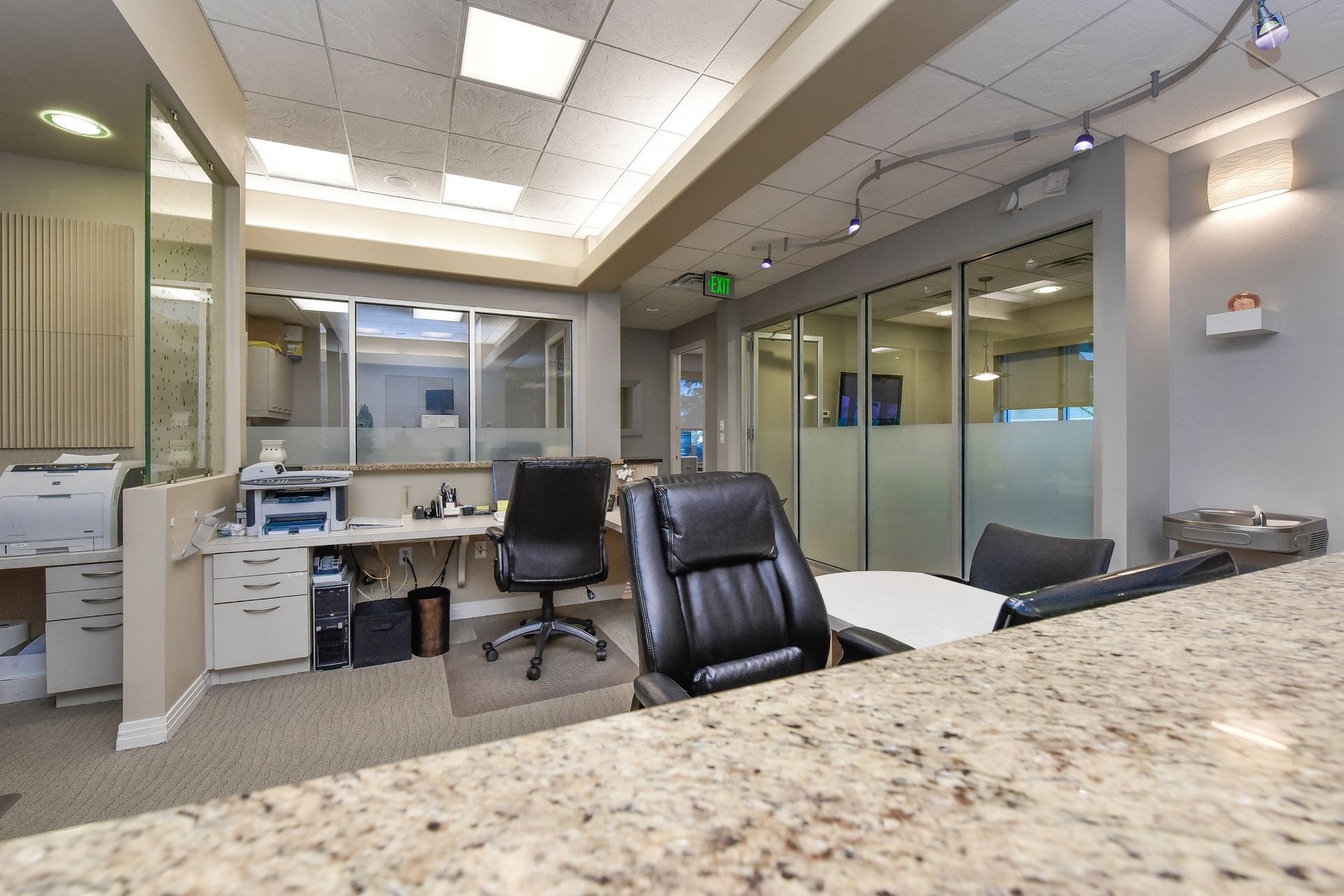 A dental office with a reception desk and chairs