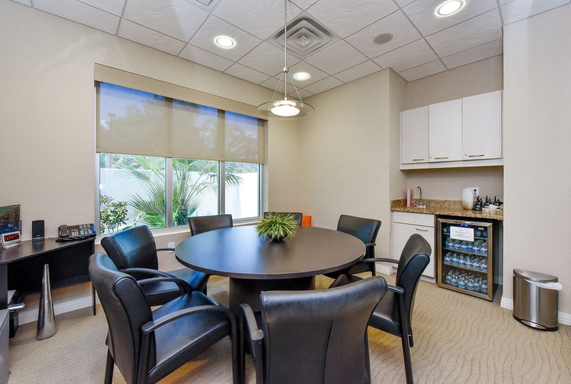 A conference room with a round table and chairs