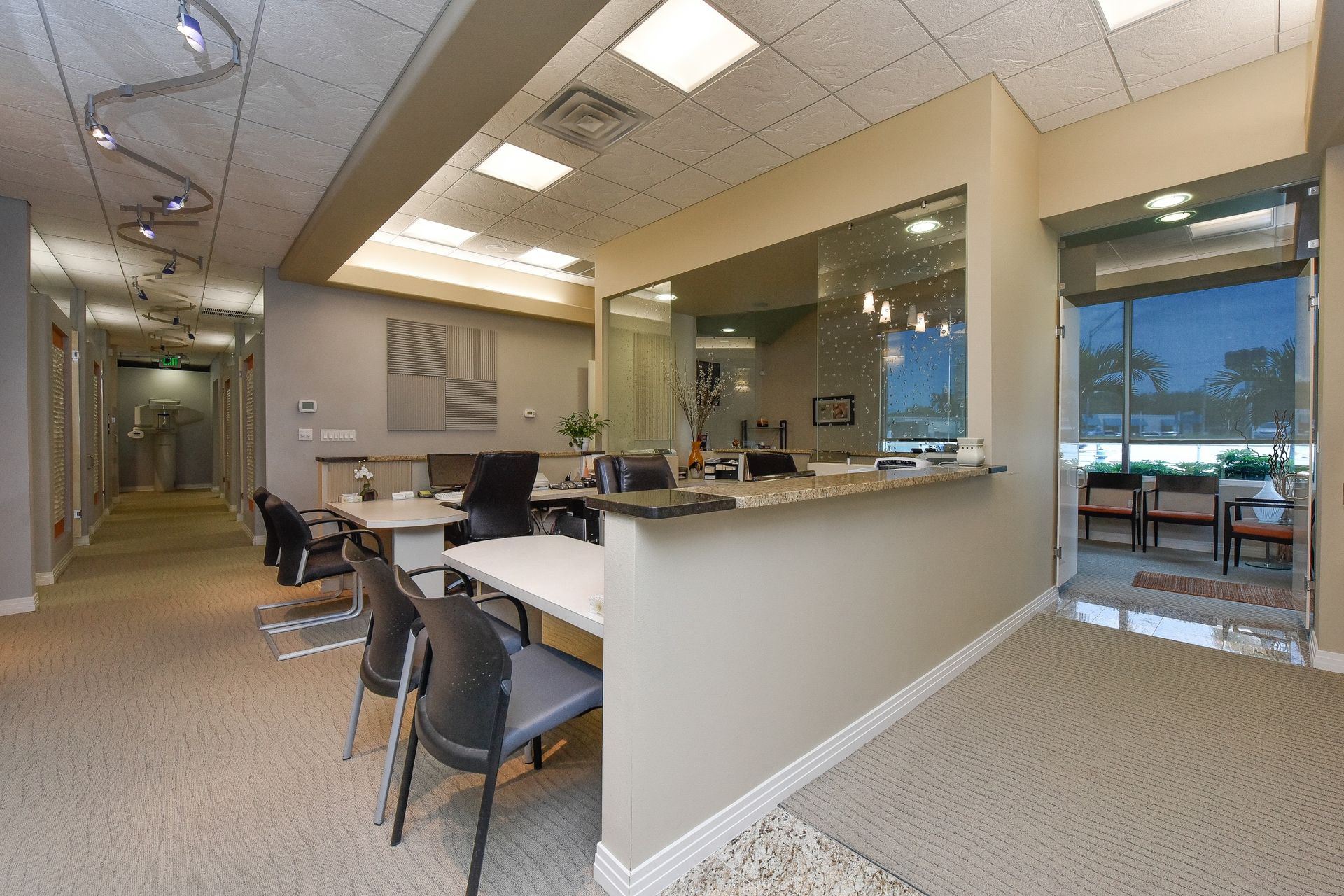 A dental office with a reception desk and chairs
