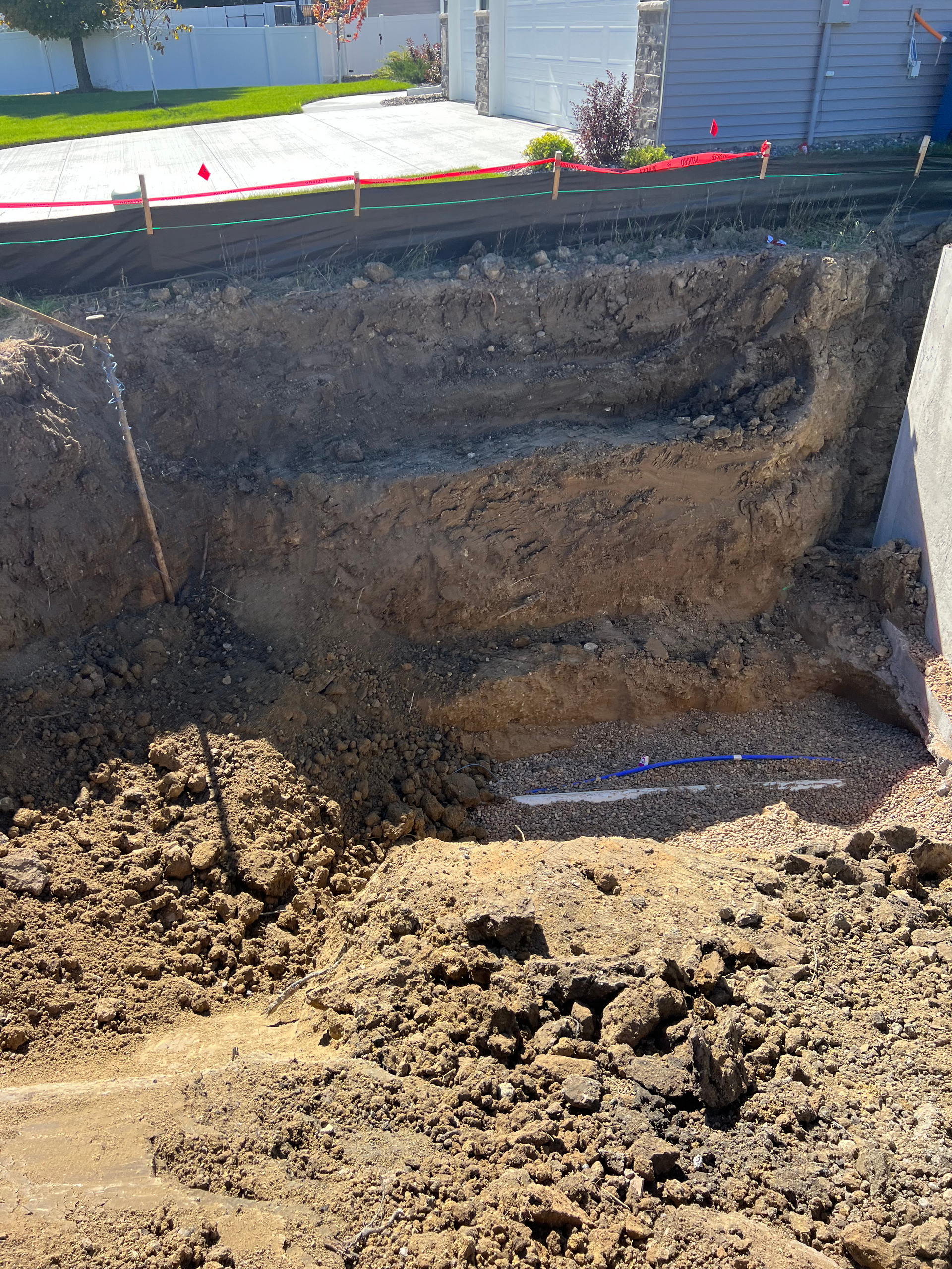 A large hole in the ground with a shovel in it.