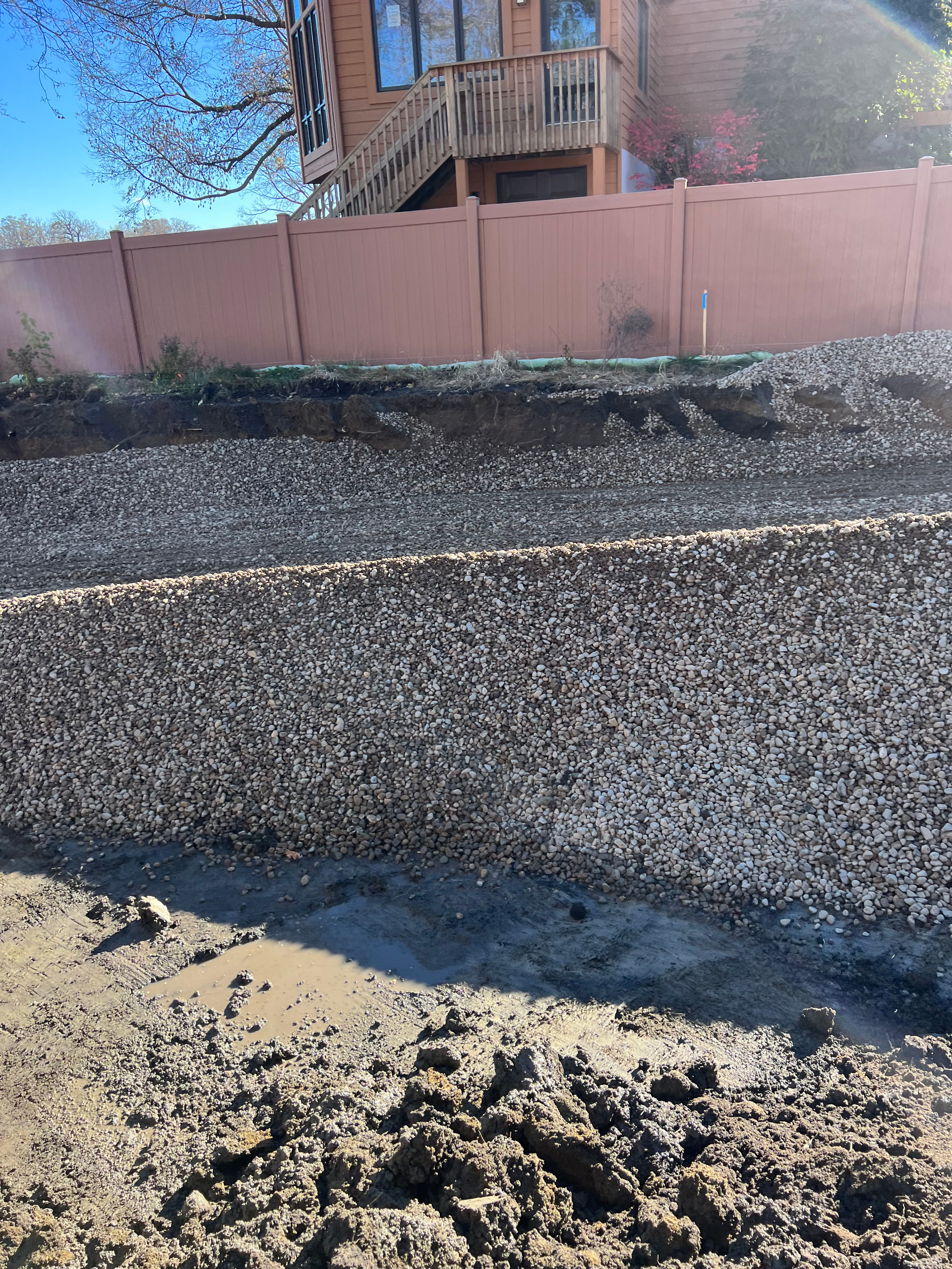 A pile of gravel is sitting in front of a house.