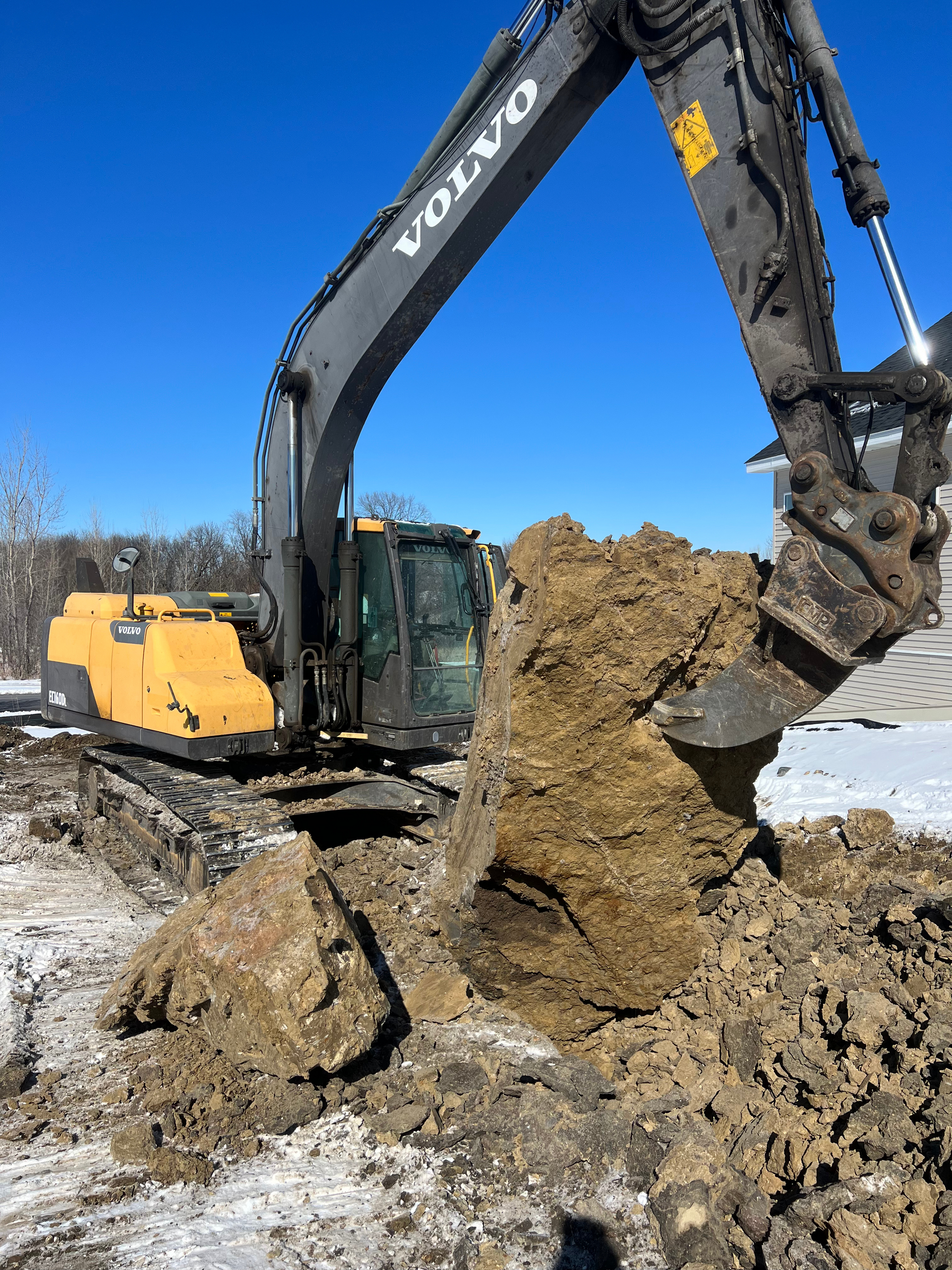 A volvo excavator is digging a hole in the ground.
