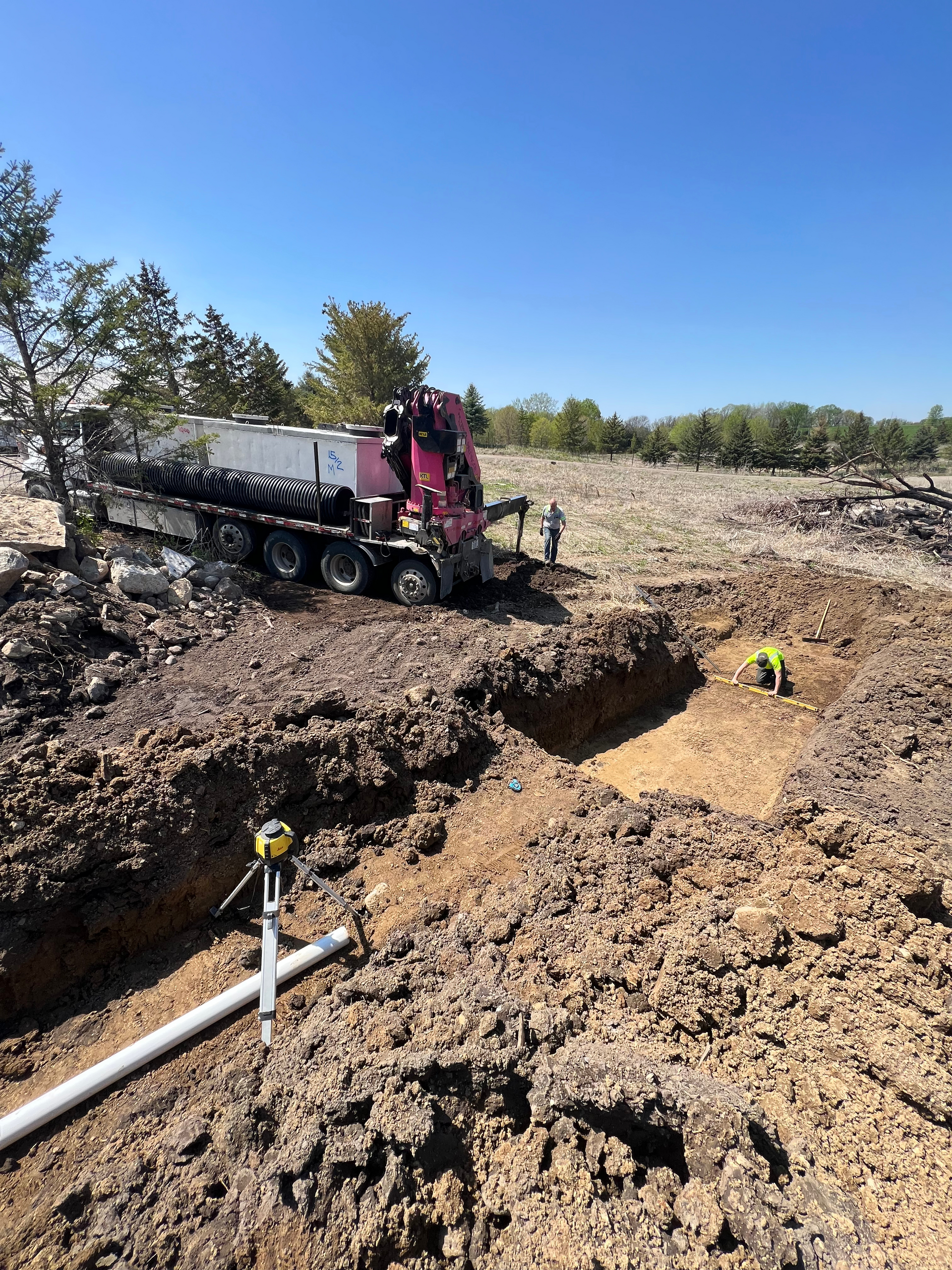 A large truck is driving through a dirt field.