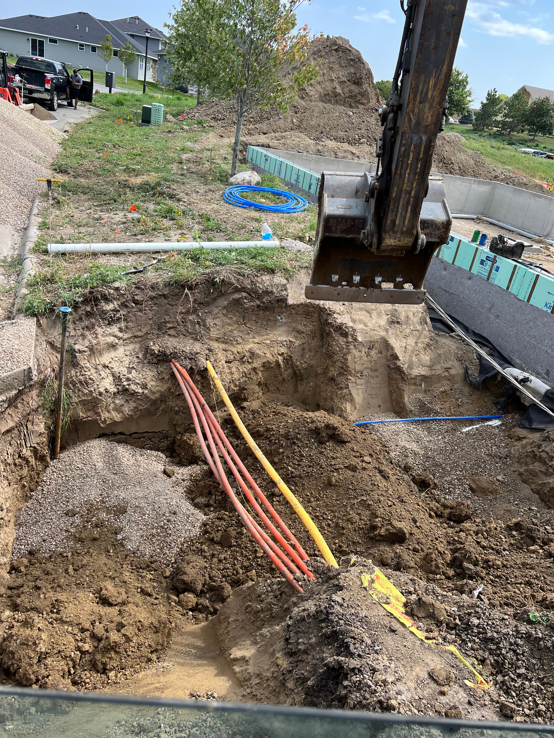 A bulldozer is digging a hole in the ground with a bunch of wires in it.
