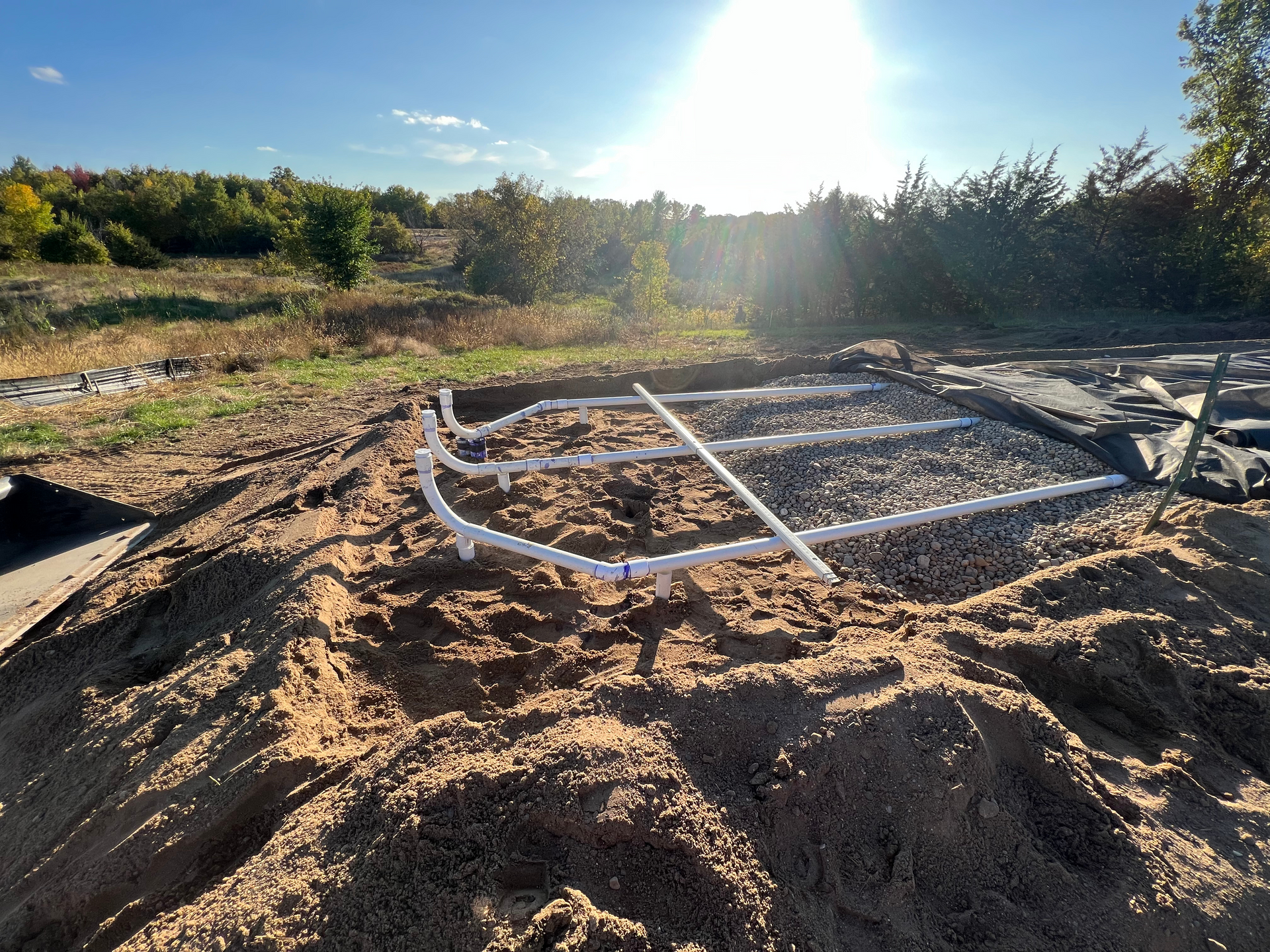 A pile of dirt and pipes in the middle of a field.