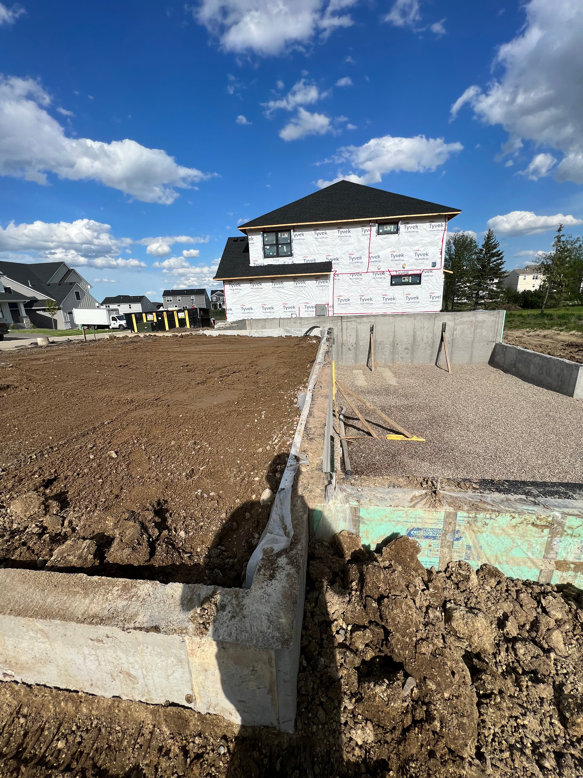 A house is being built in the middle of a dirt field.