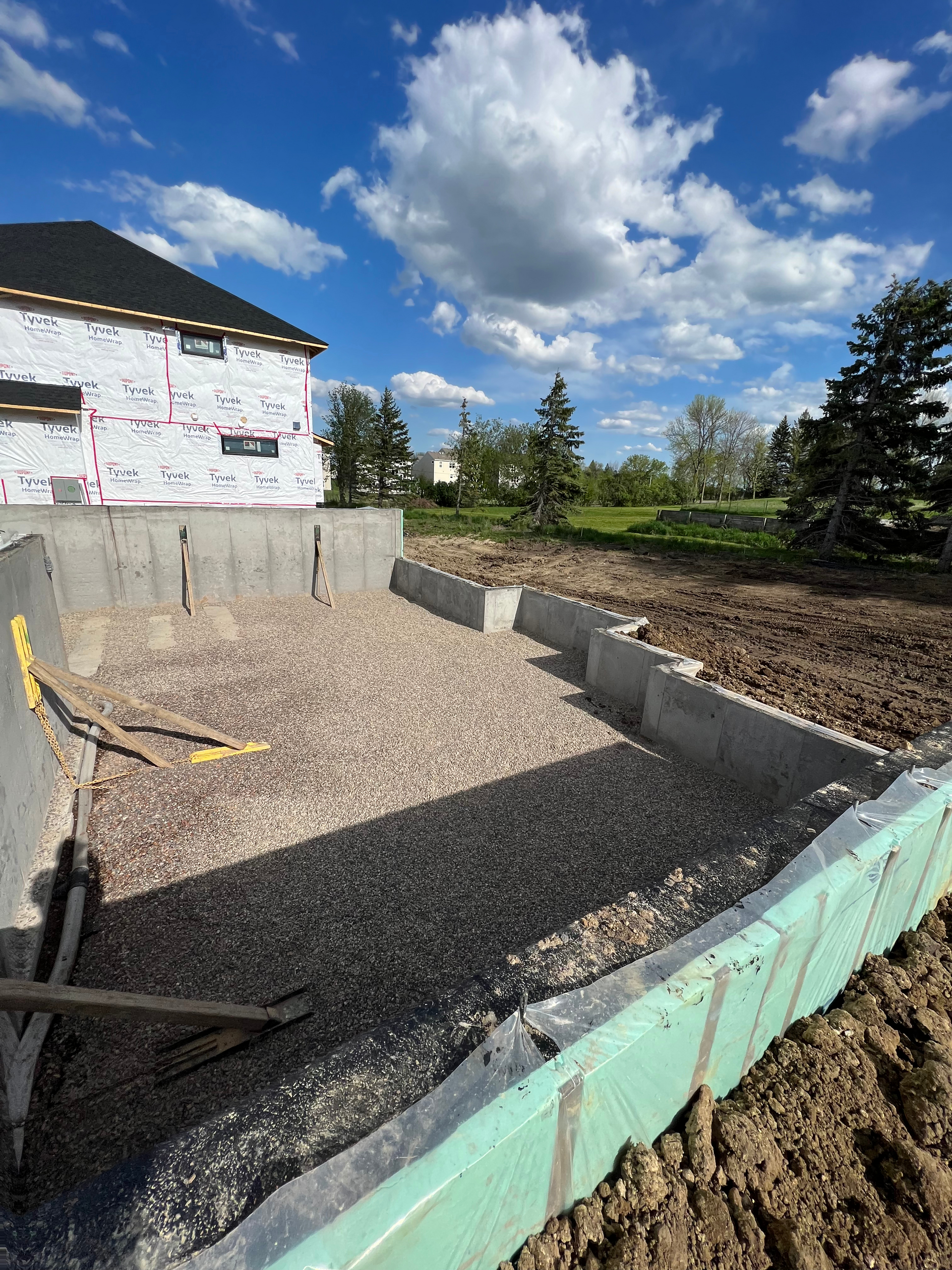 A large house is sitting on top of a dirt hill.