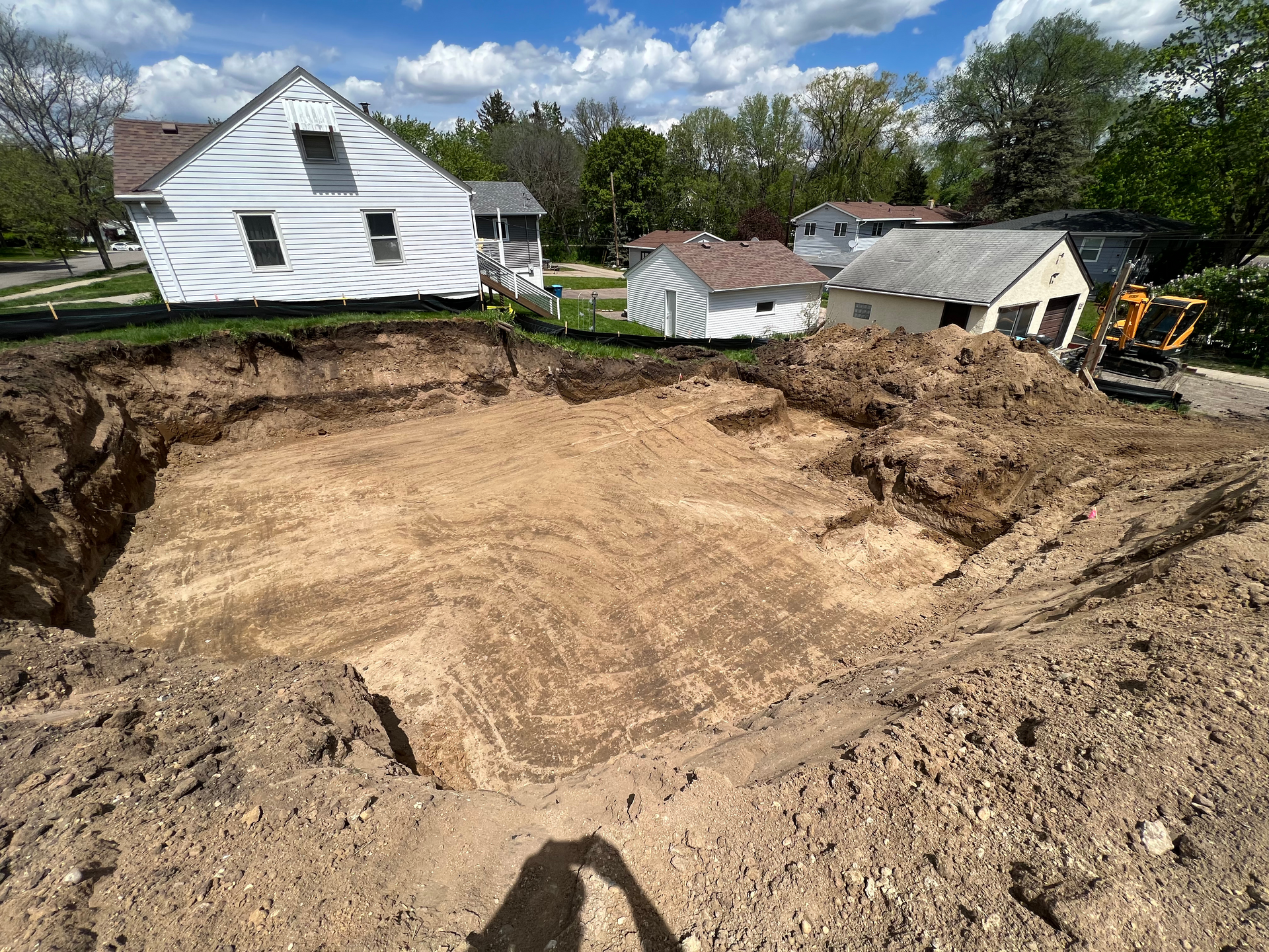 A large pile of dirt is sitting in front of a house.