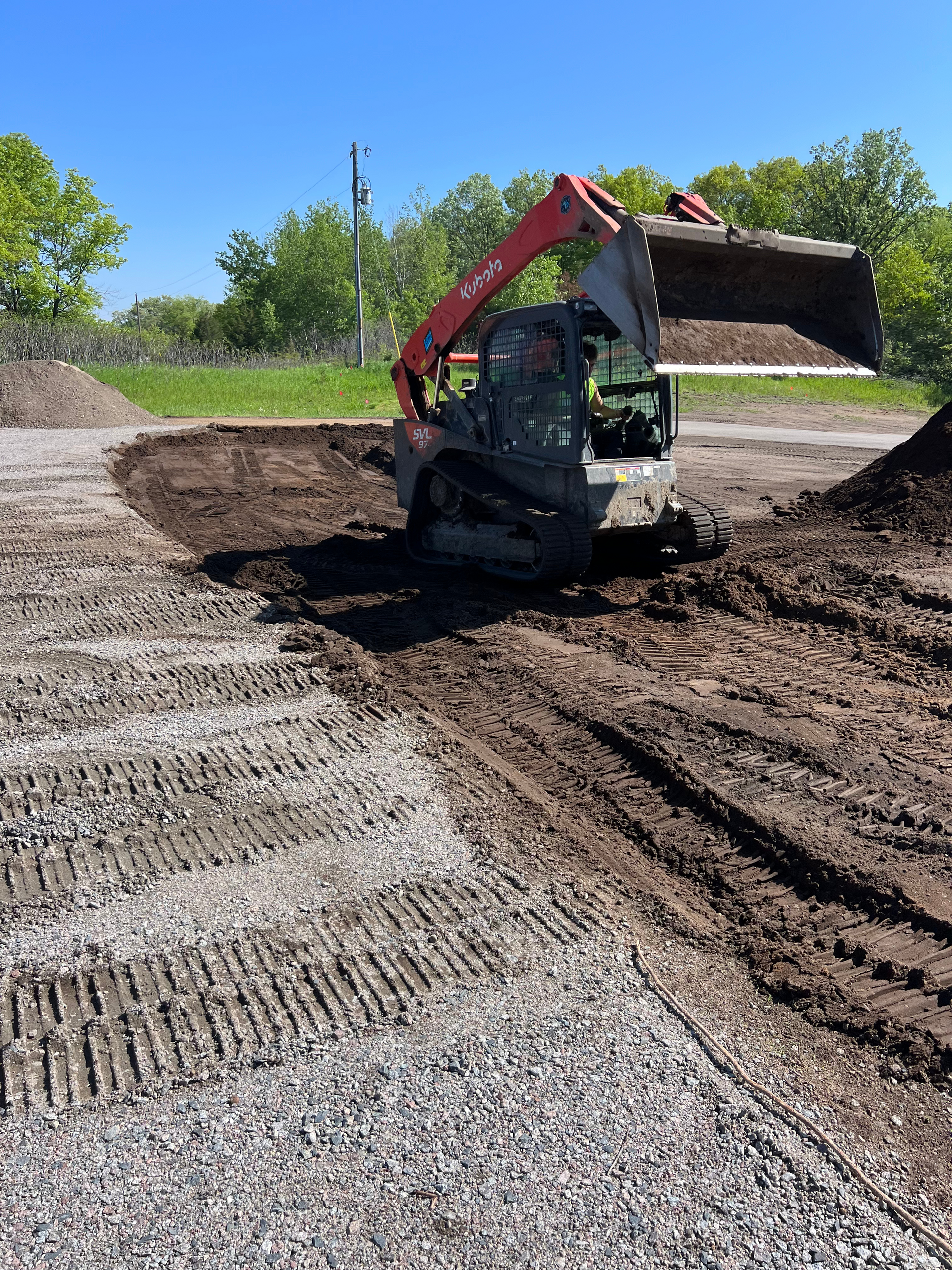 A bulldozer is driving through a dirt field.