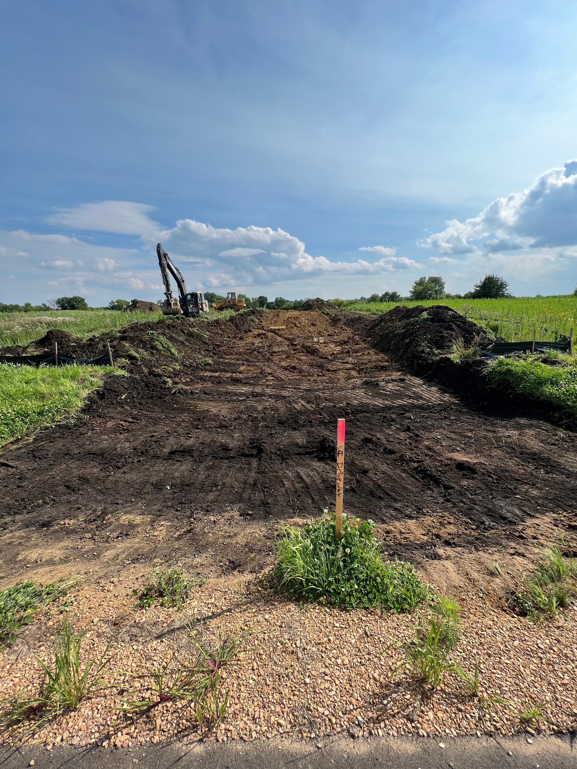 A large pile of dirt is sitting in the middle of a field.