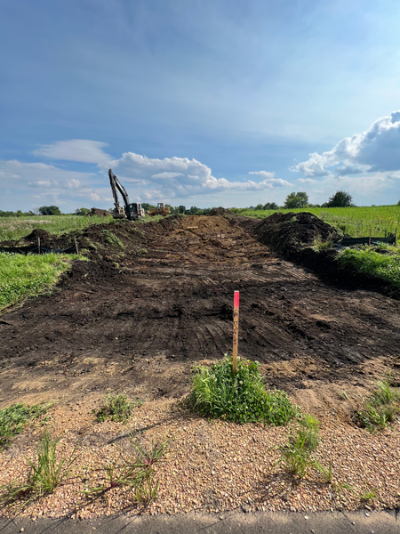 A large pile of dirt is sitting in the middle of a field.