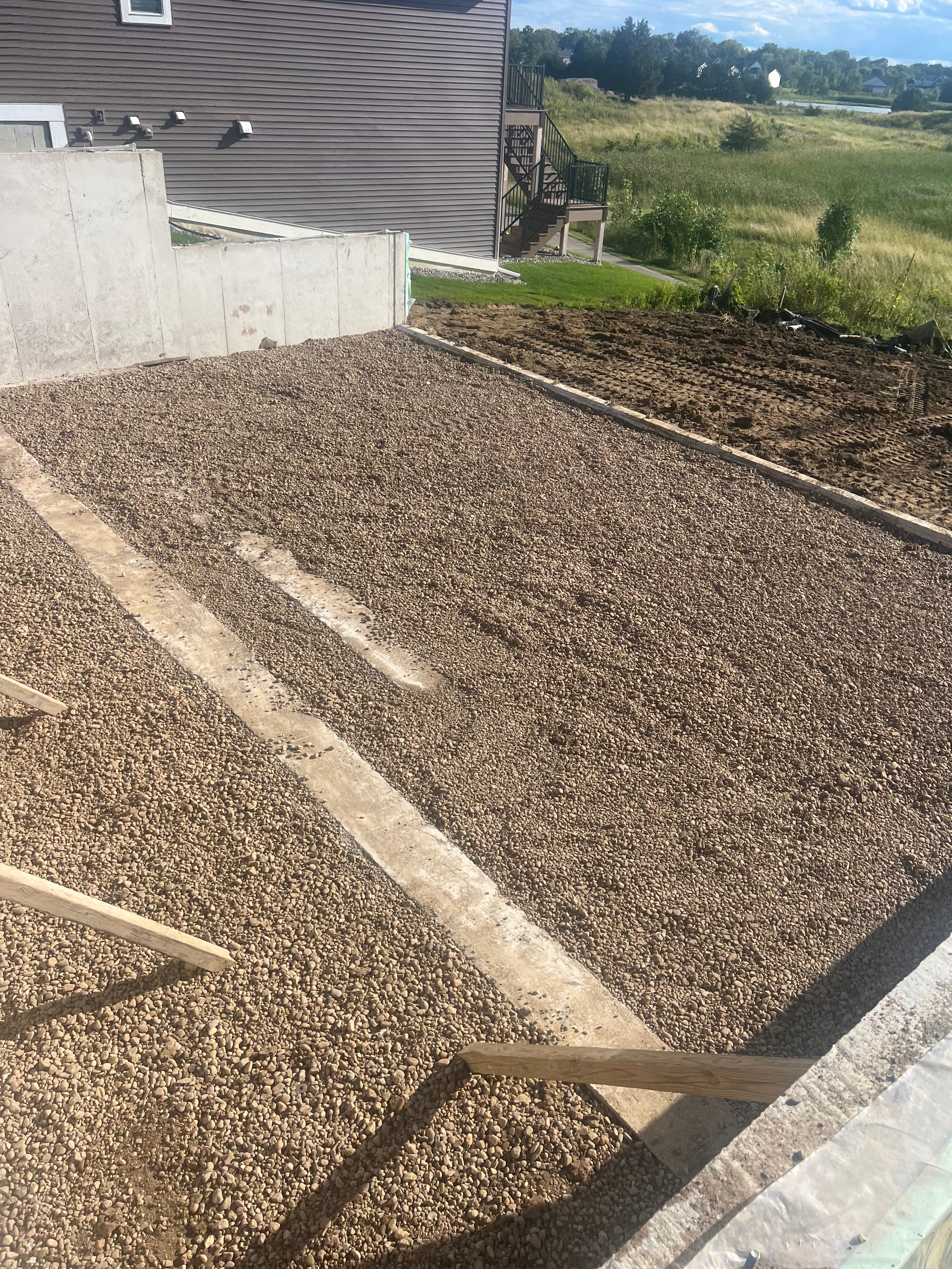 A pile of gravel is sitting in front of a house.