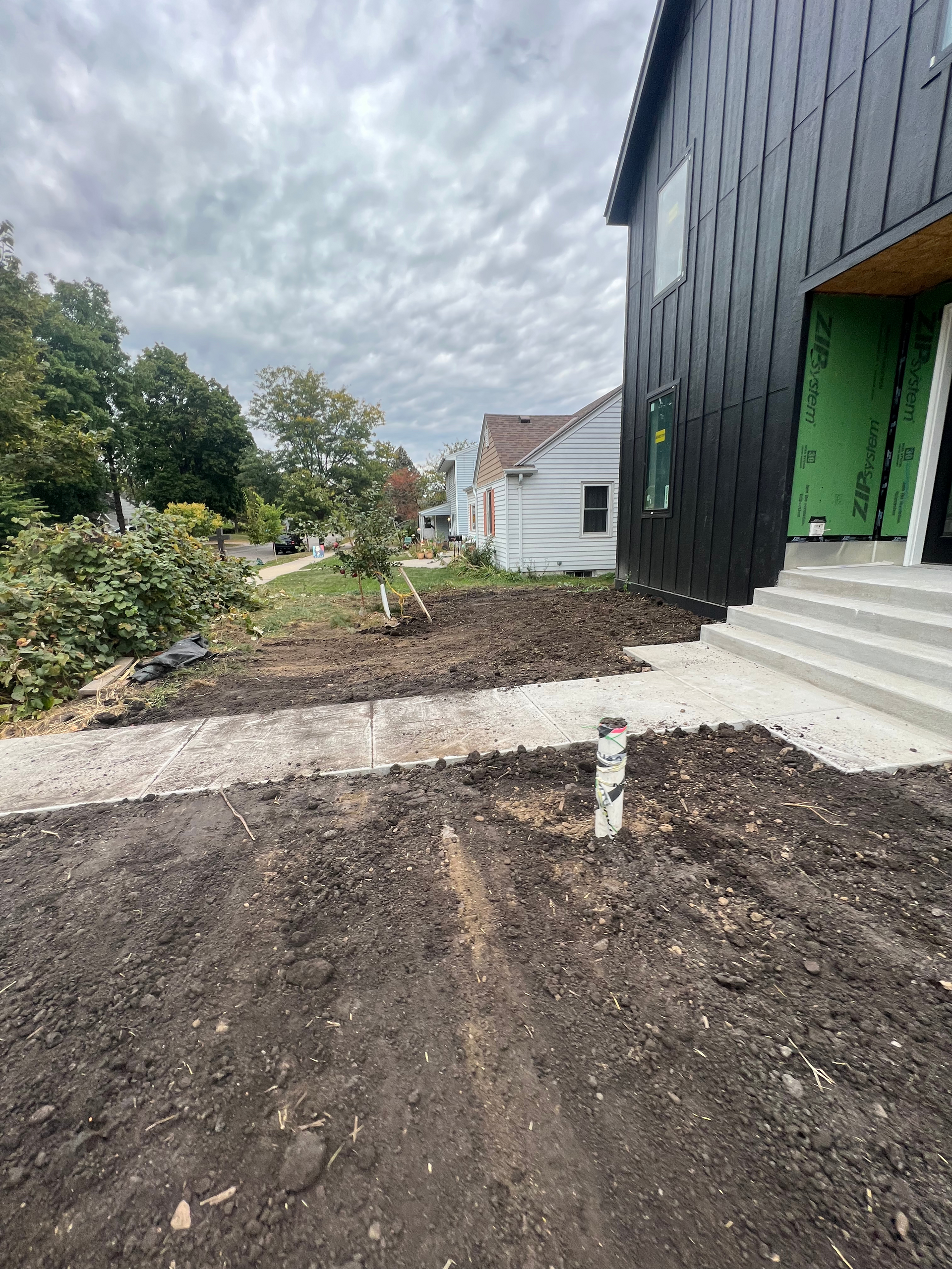 A house under construction with a lot of dirt in front of it.