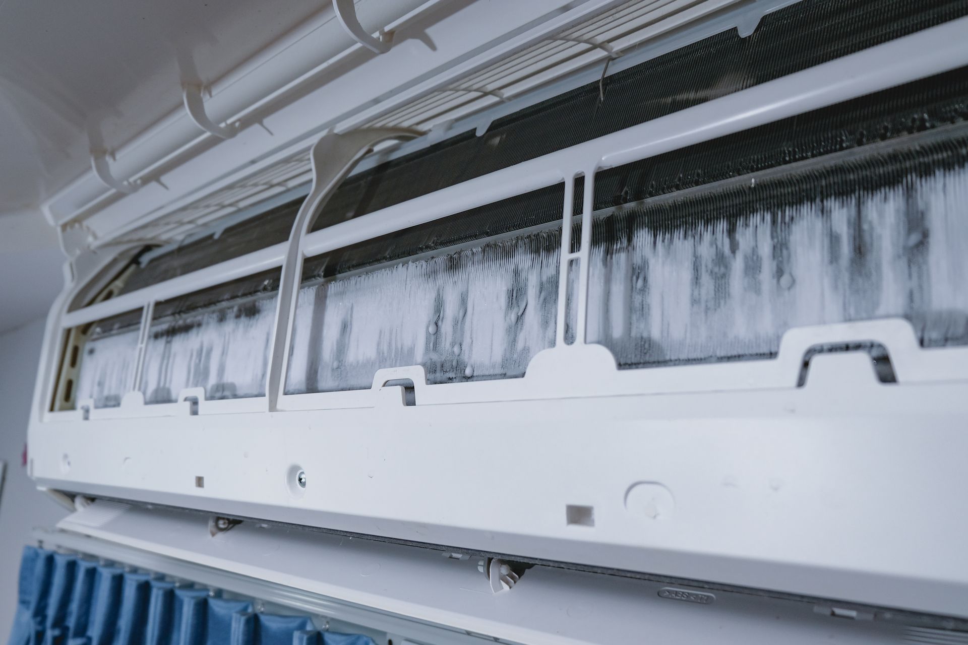 Close-up of frozen air conditioner coils with visible ice buildup.