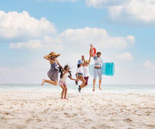 Family Doing A Jump Shot On The Beach — Lake Worth, FL — Mercer Law Immigration Attorneys