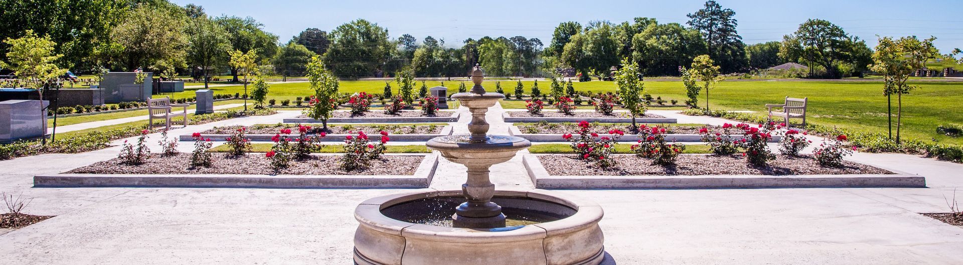 there is a fountain in the middle of a cemetery .