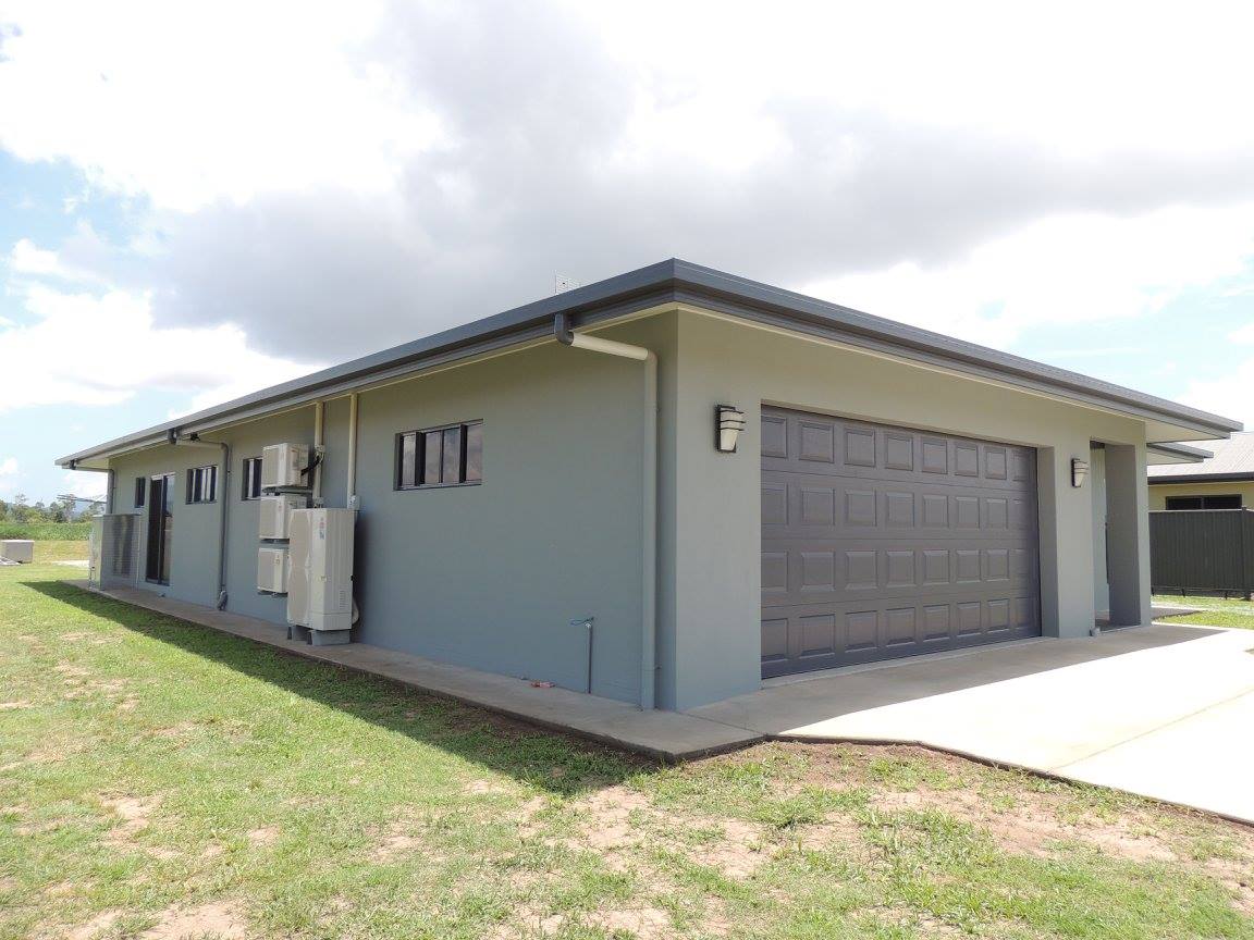 A large house with a garage and a lawn in front of it.