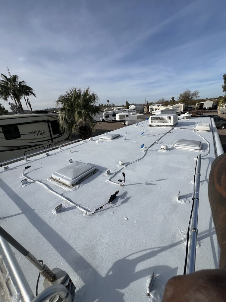 A person is standing on the roof of a rv.