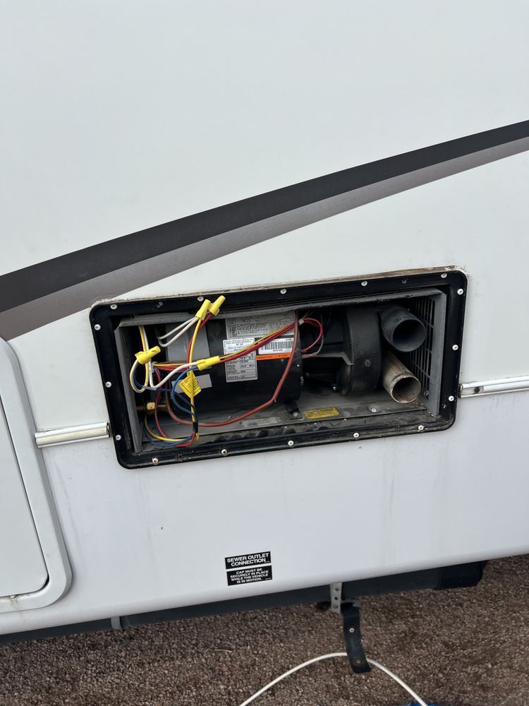 A rv with the door open and a bunch of wires coming out of it.