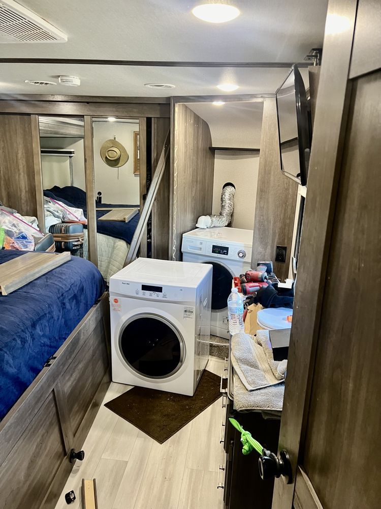 A laundry room in a rv with a washer and dryer.