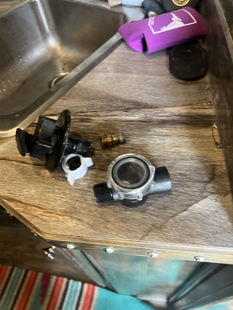 A piece of metal is sitting on a counter next to a sink.