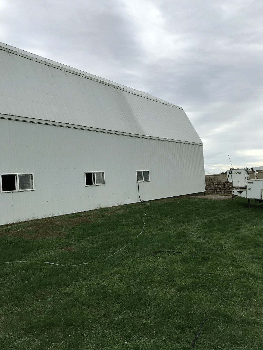 a large white barn with a trailer parked in front of it .