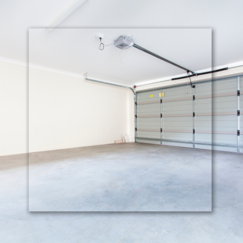 Empty garage with a concrete floor and a closed gray garage door.